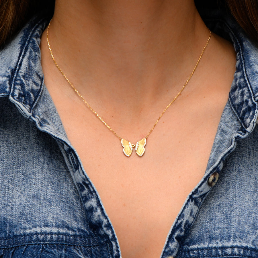 model wearing gold butterfly necklace