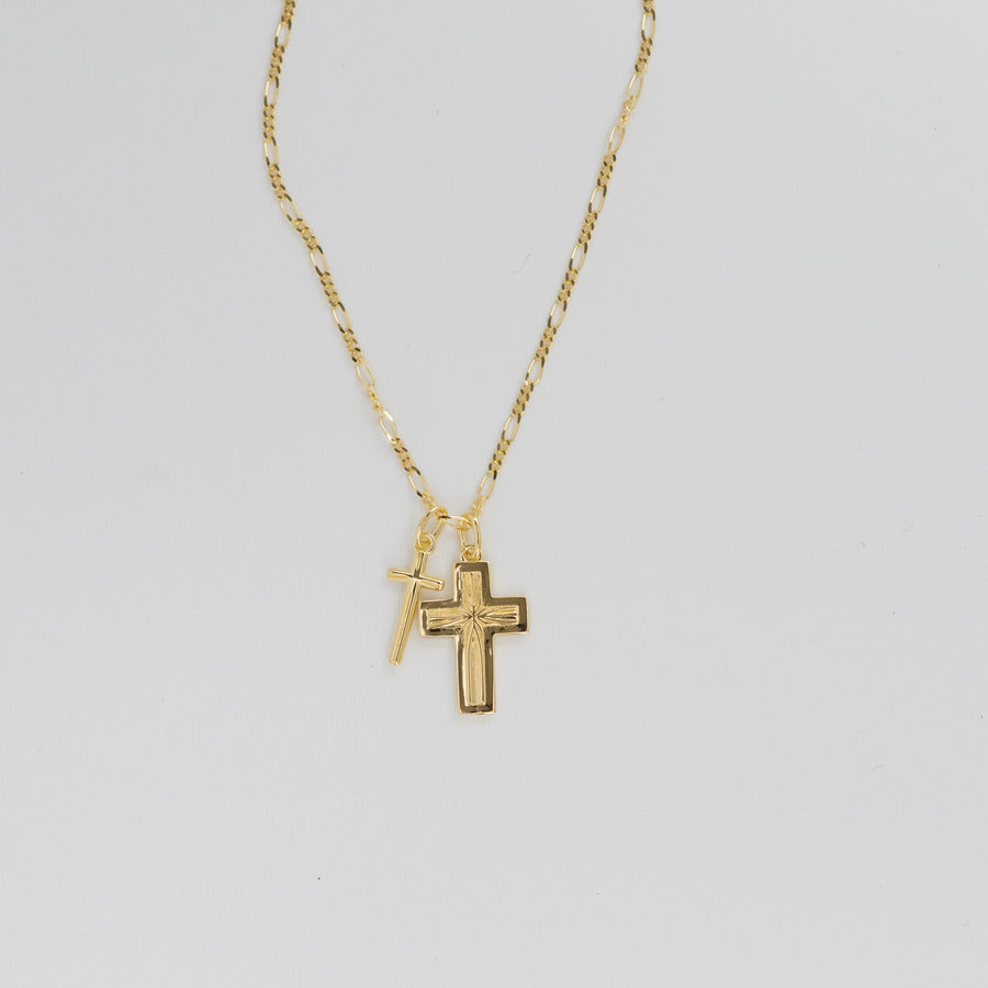 two gold crosses on a figaro chain 