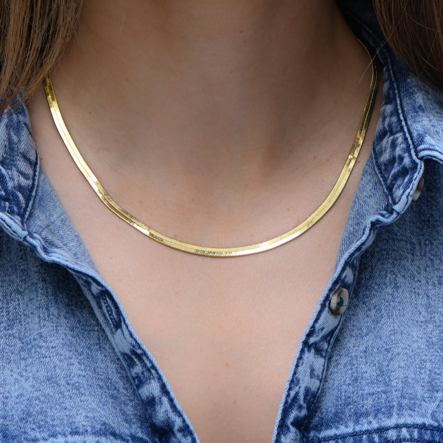 model wearing a gold herringbone chain necklace