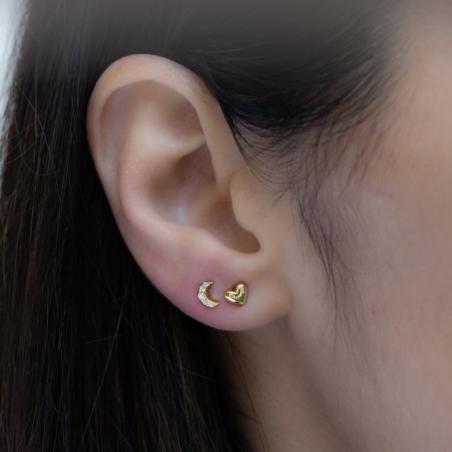 gold heart stud earrings paired with a dainty moon stud