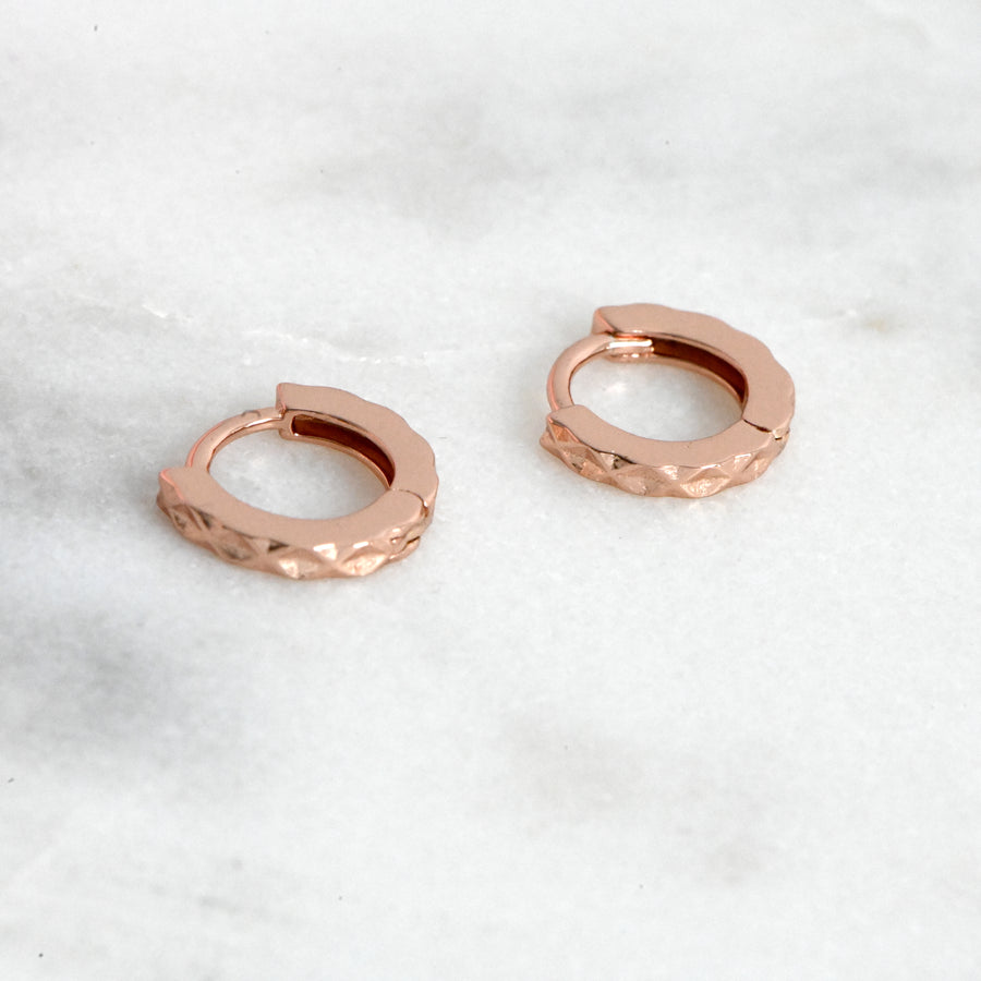 rose gold huggie hoop earrings with a geometric pattern design 