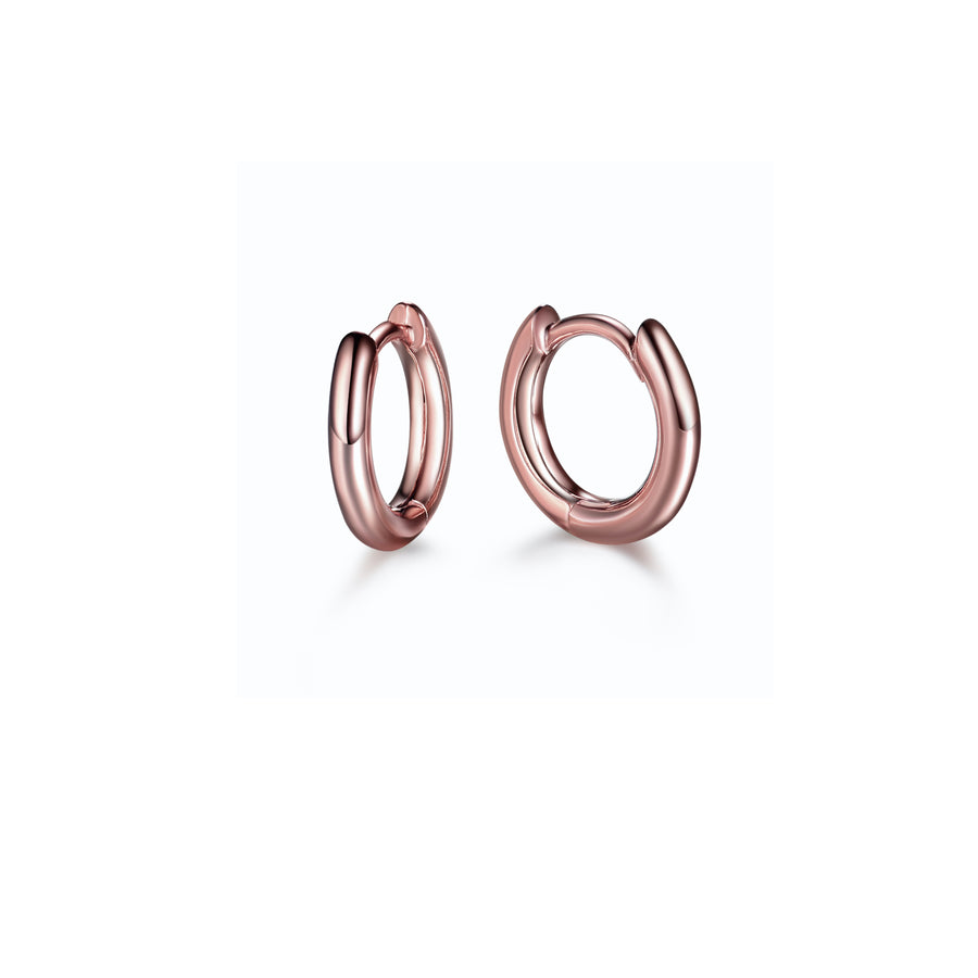a pair of minimalist rose gold huggie hoop earrings 