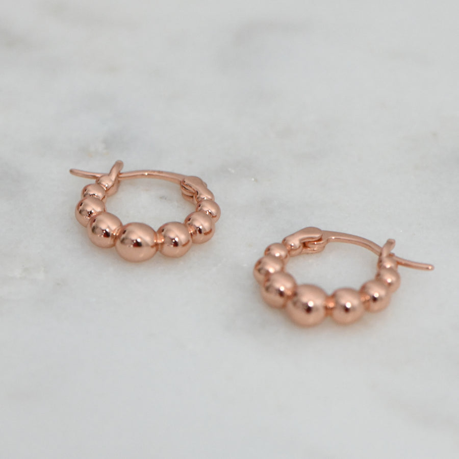 a pair of rose gold graduated bead, small hoop earrings